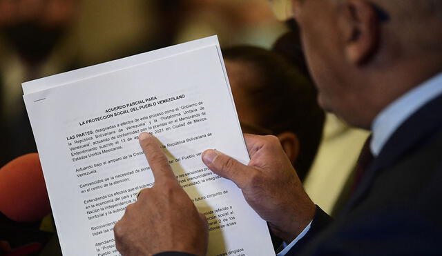 El jefe de la delegación del Gobierno venezolano, Jorge Rodríguez, señala el manifiesto que se acordó con la Plataforma Unitaria. Foto: AFP