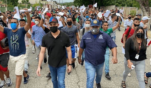 El Gobierno chavista continúa liberando a cientos de presos. En imagen, exreos caminando por la avenida Andrés Bello con sus boletas de excarcelación en mano. Foto: Twitter/Jhorman Cruz