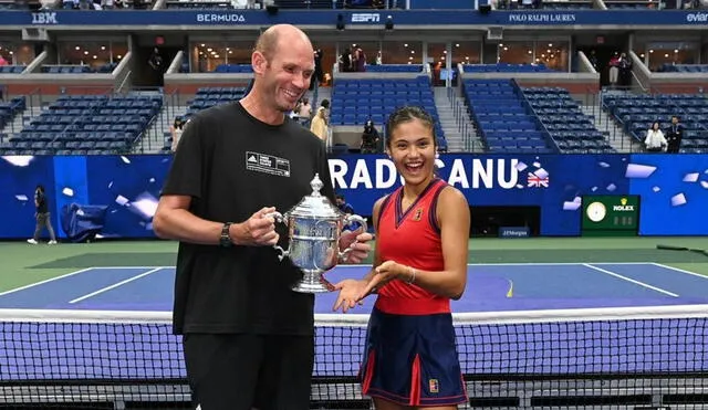 Emma Raducanu y Andrew Richardson posando con el trofeo en el estadio Arthur Ashe de Nueva York. Foto: WTA.