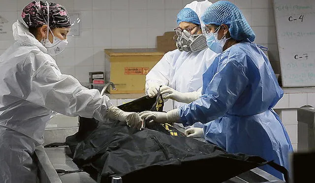 Procedimiento. Los técnicos forenses inician la extracción del cadáver de Guzmán que se encontraba en el frigorífico desde que llegó a la morgue, el 11 de setiembre. Foto: Mininter