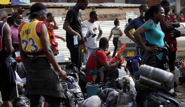 Migrantes haitianos esperan abordar un bote para navegar hacia la frontera con Panamá en Necoclí, Colombia. Foto: AFP