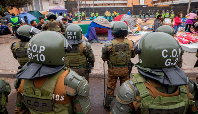 El desalojo en la Plaza Brasil, en Iquique, derivó en violencia y terminó con cinco personas detenidas y una carabinera herida. Foto: EFE