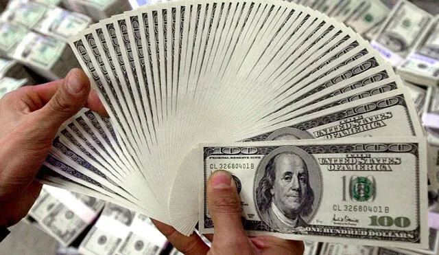 Compradores y vendedores chequean con asiduidad el dólar BCV en Venezuela. Foto: AFP
