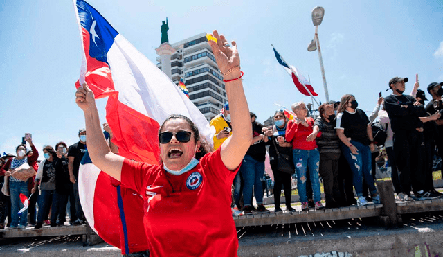 Empuñando banderas chilenas y con cacerolazos, cientos de personas se congregaron para protestar contra la entrada de migrantes irregulares en Iquique. Foto: AFP