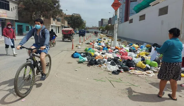Ciclistas se ven obligados a ocupar el carril de vehículos para pasar por este tramo de la ciclovía bloqueado por basura. Foto: Clinton Medina/La República.