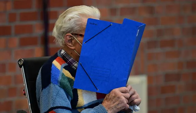 El acusado esconde su rostro detrás de una carpeta cuando llega para su juicio en Brandenburg an der Havel, en el noreste de Alemania, el 7 de octubre de 2021. Foto: Tobias Schwarz/AFP