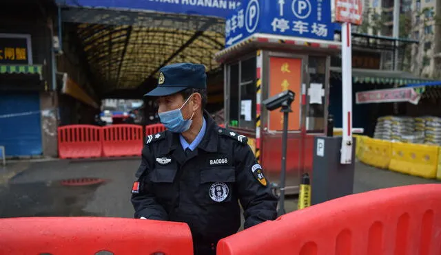 Un oficial de policía monta guardia fuera del mercado mayorista de mariscos de Huanan, donde se detectó el coronavirus en Wuhan el 24 de enero de 2020. Foto: AFP