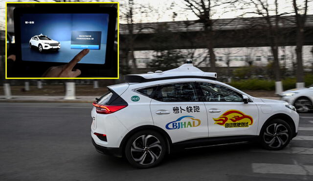 Un Apollo Go sin conductor trasladándose en China. A la izquierda, un pasajero activa las características del vehículo. Foto: Jade Gao / AFP