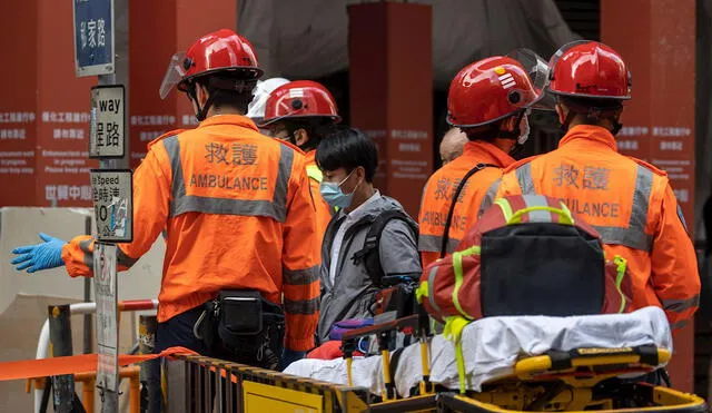 Un hombre pasa junto a los paramédicos después de ser evacuado del edificio del World Trade Center en Causeway Bay. Foto: EFE