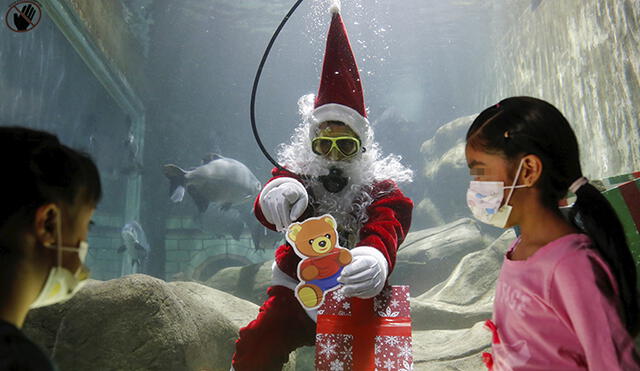 Santa entrega regalos a niños en un zoológico de Guadalajara. Foto: EFE