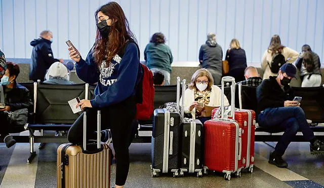 Viajes truncos. Pasajeros revisan la situación de sus vuelos en el aeropuerto de New York. Foto: EFE