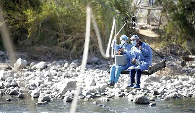 Loable  El fotoperiodista Diego Ramos retrata a enfermeros que viajan sobre un andarivel para cruzar el río Colca e inmunizar a poblados de Castilla que viven incomunicados.