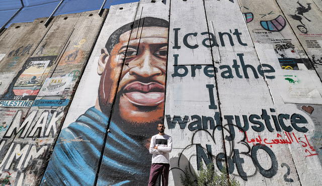Mural pintado por el artista Taqi Spateen que representa a George Floyd, un hombre negro desarmado que murió después de que un policía blanco se arrodillara en el cuello durante un arresto. Foto: AFP