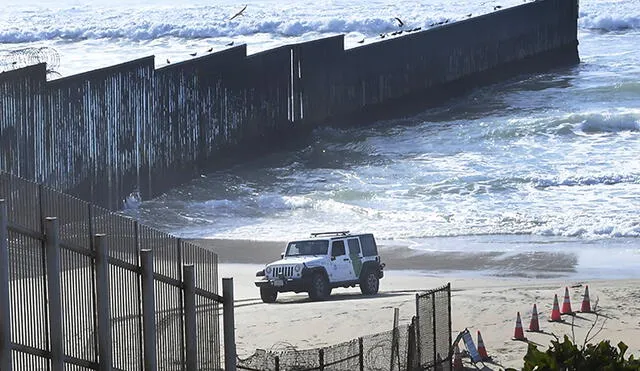 Un vehículo de la Patrulla Fronteriza de EE. UU. pasa por la valla fronteriza entre este país y México que desemboca en el océano Pacífico. Foto: AFP