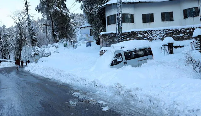 El vehículo de los turistas está varado en una carretera cubierta de nieve en una zona afectada por fuertes nevadas en Murree, Pakistán. Foto: EFE