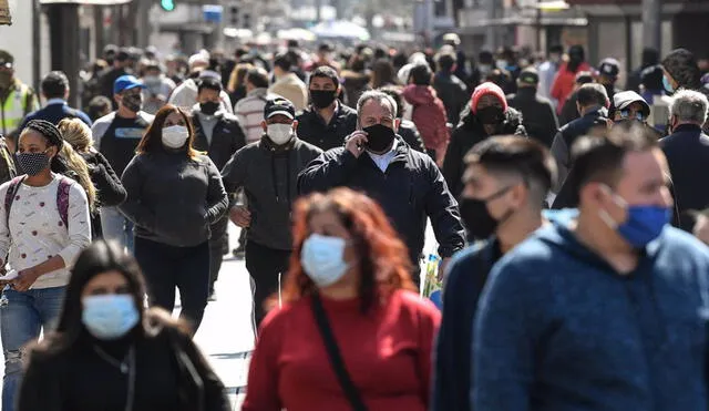 Personas con mascarilla transitando en una calle de Santiago de Chile. Foto: Jorge Villegas / Xinhua News