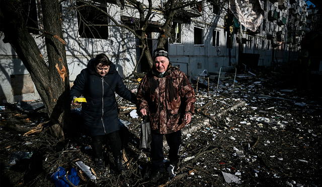 Dos personas luego del bombardeo ruso en la ciudad de Chuguiv, en el este de Ucrania, el 24 de febrero. Foto: ARIS MESINIS/ AFP