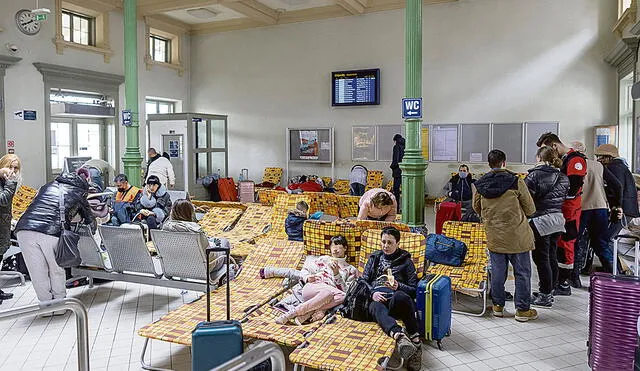En Polonia. Ucranianos descansan en la estación ferroviaria polaca de Przemysl, convertido en centro de refugiados que huyen de la guerra desatada por Rusia. Foto: AFP
