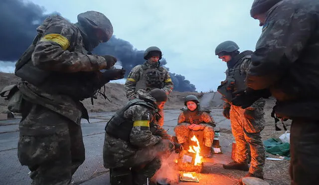 Soldados ucranianos se calientan en una hoguera en las inmediaciones de Kiev, capital de Ucrania, este domingo. Foto: EFE