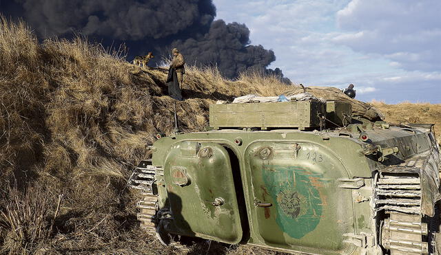 Alertas. Un soldado ucraniano con su perro vigilan desde una trinchera una vía que conduce a unos depósitos de combustible atacados por los rusos. Foto: EFE
