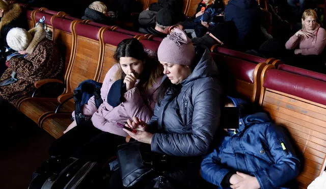 Una mujer y niños sentados en la estación principal de tren de Lviv, en el oeste de Ucrania, el 28 de febrero. Foto: AFP