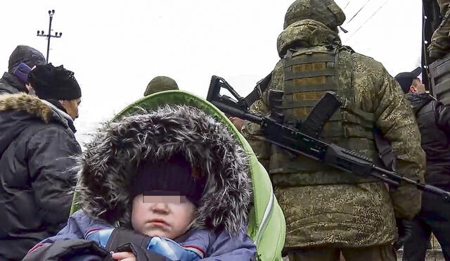 Huyen de su tierra. Un niño ucraniano espera el turno de sus padres para pasar a Polonia. Foto: EFE