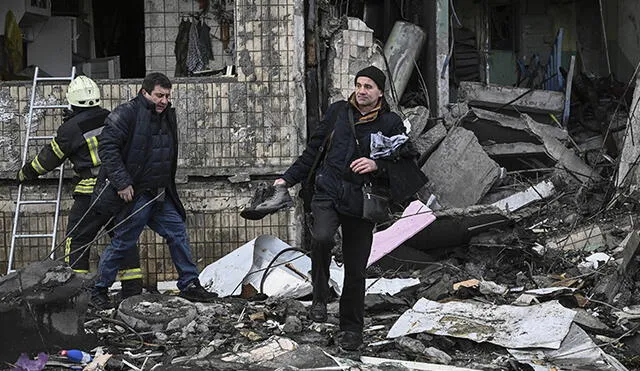 Un hombre recupera artículos de un bloque de apartamentos destruido tras un bombardeo en Kiev (Ucrania). Foto: AFP
