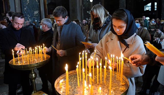 Fieles encienden velas durante una misa dominical en la Iglesia Católica Saints Peter and Paul Garrison en la ciudad de Lviv, oeste de Ucrania. Foto: AFP