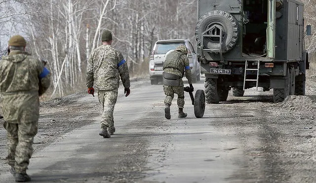 Retirada. Soldados ucranianos tratan de revisar un camión ruso abandonado en medio de la carretera que va hacia la frontera. Foto: difusión