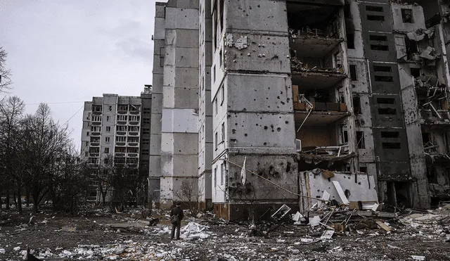 Un hombre se para frente a un edificio residencial dañado en un bombardeo en la ciudad de Chernihiv. Foto: AFP