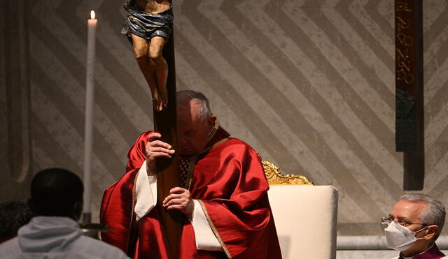 El papa Francisco sostiene el crucifijo de San Marcello durante la adoración de la Santa Cruz, mientras preside la Liturgia de la Pasión del Señor este Viernes Santo. Foto: AFP