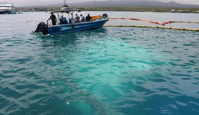 Rangers colocan material absorbente donde un barco se hundió cerca de Puerto Ayora en la Isla Santa Cruz, en las Islas Galápagos. Foto: AFP