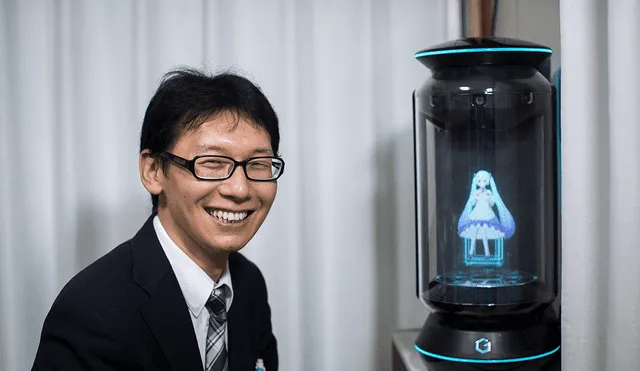 Akihiko Kondo posa junto al holograma Hatsune Miku, en su departamento en Tokio, una semana después de casarse con ella. Foto: AFP