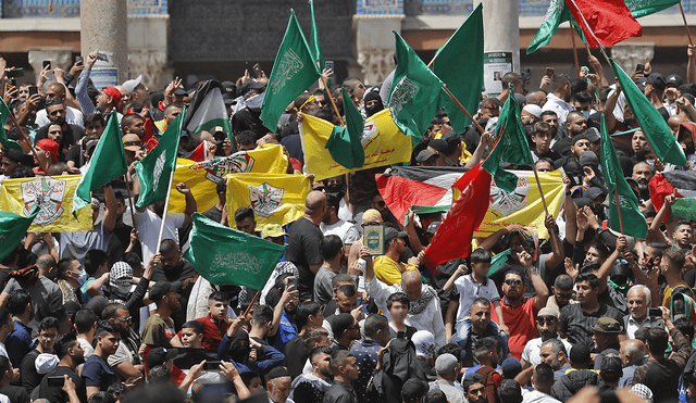 Manifestantes palestinos ondean banderas palestinas e islámicas frente a la mezquita de la Cúpula de la Roca en el complejo de la mezquita de Al-Aqsa en Jerusalén. Foto: AFP