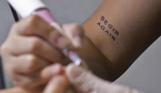 Tatuaje en el brazo de la manicurista venezolana Yara González mientras trabaja en un salón de belleza en Caracas, el 17 de enero de 2022. Foto: AFP