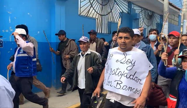 El imputado de robo, cargando un cartel que decía "Yo soy el estafador de bancos", caminó hasta la plaza de armas de Chota. Crédito: captura de vídeo/Telesystem Noticias.
