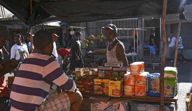 Un comerciante venezolano espera clientes mientras vende diferentes productos de la canasta básica familiar en el mercado callejero de Guiria. Foto: AFP