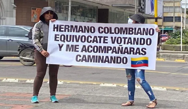 Migrantes venezolanos en las calles de Bogotá portan pancartas con advertencias para los ciudadanos colombianos que votarán el 19 de junio. Foto: NTN24