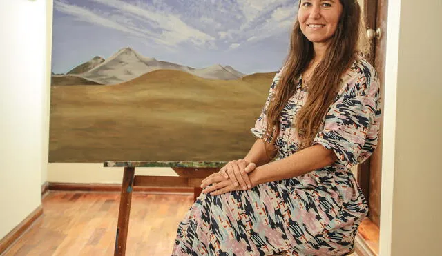 Ximena Heraud posa al lado de una de sus pinturas que recrea paisajes peruanos. Fotografía John Reyes. La República.