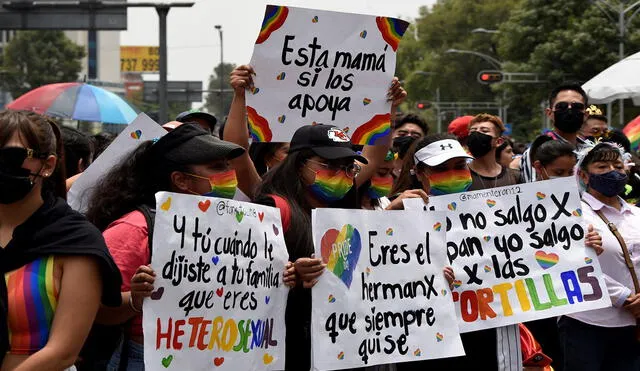 Las personas sostienen carteles que apoyan la diversidad de género durante el Desfile del Orgullo en la Ciudad de México el 25 de junio de 2022. Foto: AFP