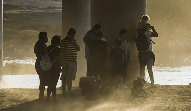 Una familia migrante se encuentra en medio de una tormenta de polvo en Eagle Pass, Texas, cerca de la frontera con México. Foto: AFP