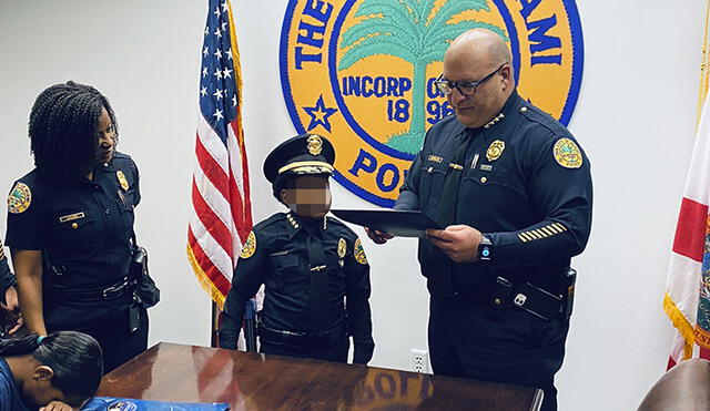 El niño Daniel DJ posa con miembros del departamento de Policía de la ciudad de Miami. Foto: EFE