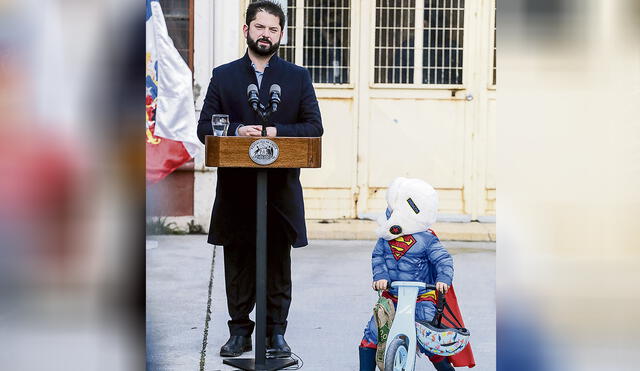 Súperpoderes. Un niño chileno deja de jugar para escuchar al presidente Gabriel Boric. Foto: EFE