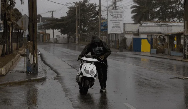 Un hombre empuja su motocicleta en busca de combustible, hoy en Nagua (República Dominicana). Foto: EFE
