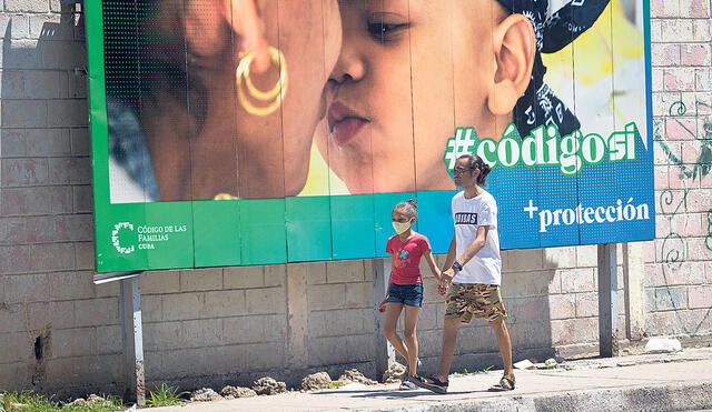 Referendo. Un hombre y su hija pasan caminando frente a una valla que hace parte de la campaña por el SÍ en el referendo sobre el código de familia. Foto: EFE
