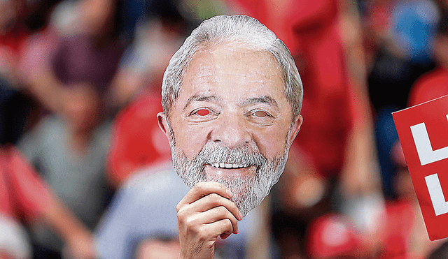 Caras y caretas. Un partidario de Lula da Silva muestra una máscara del exmandatario en el último día de la campaña. Foto: EFE