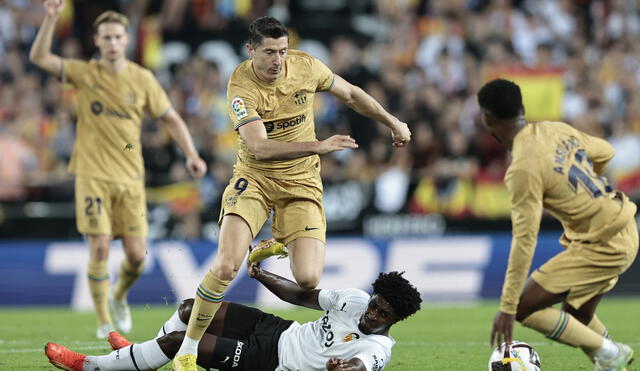 Robert Lewandowski supera al jugador del rival durante el partido entre Valencia CF y FC Barcelona. Foto: EFE