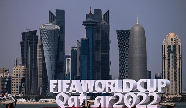 La gente visita la cornisa adornada con un cartel de la FIFA en Doha, capital de Qatar y la Copa Mundial de la FIFA 2022. Foto de Joya SAMAD / AFP