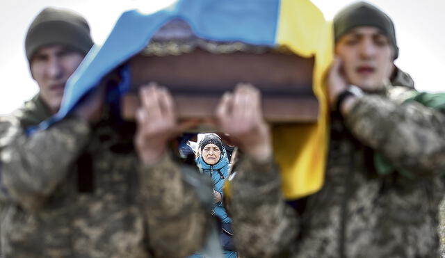 Sin atisbos de la paz. Una ciudadana de Kiev acompaña el ataúd con los restos de su hijo muerto en los combates con las tropas rusas en la frontera. Foto: EFE