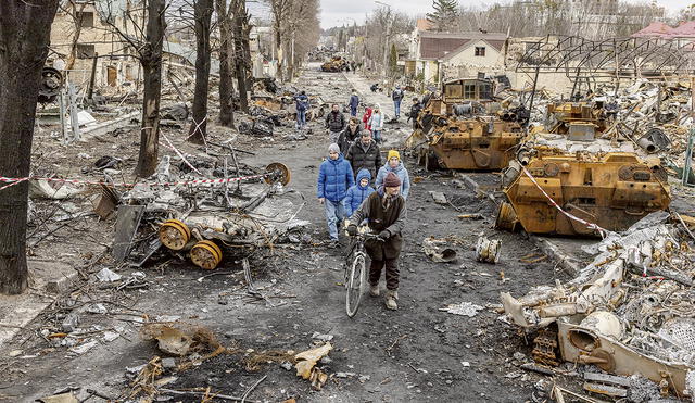 El horror de la guerra. Un grupo de vecinos ucranianos abandona sus refugios y escapa de su barrio repleto de blindados destruidos luego de los violentos combates con los rusos. Foto: EFE